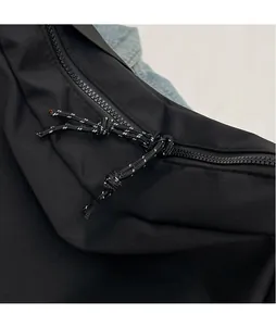 Detailed close-up of a smooth zipper with black and white woven pull cord on nylon bag