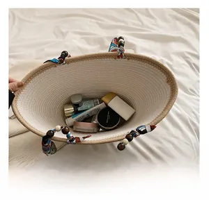 Vue de dessus de l'intérieur du sac tissé beige avec perles en bois et foulard en soie