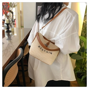 Détail du sac bandoulière en paille avec garniture en cuir et broderie RESTAIN élégante