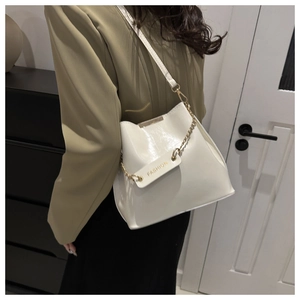 Détail d'un sac seau blanc en cuir PU avec chaîne dorée et étiquette FASHION chic