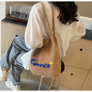 Détail de la broderie Summer et fleur jaune sur un sac à bandoulière tissé kaki