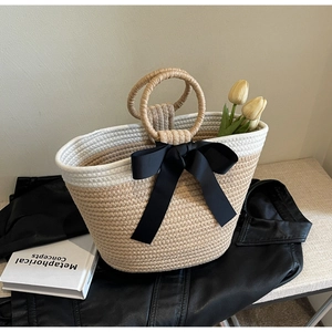 Fashionable woven straw handbag with black ribbon bow and dual round rope handles