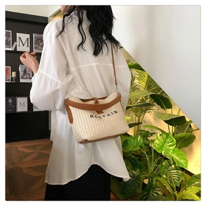 Détail d'un sac seau tissé avec bordure en cuir marron et logo RESTAIN imprimé