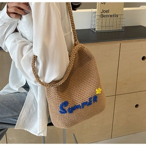 Détail du sac à bandoulière tissé avec broderie bleue Summer et une petite fleur jaune