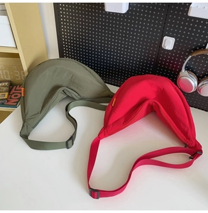 Detail of minimalist nylon crescent bags in olive and red colors with adjustable straps