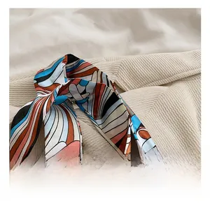 Vue détaillée d'un foulard en soie à motifs abstraits sur un sac à bandoulière en velours