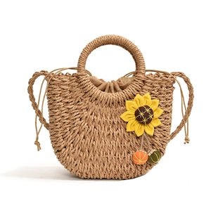 Fashionable straw shoulder bag with sunflower detail and colorful tassels for summer beach
