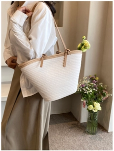 Gros plan du sac cabas tissé blanc avec lanières en PU marron porté par un mannequin