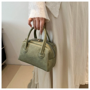 Detail view of matcha green retro Boston bag with Lady bags embossed logo and stitching