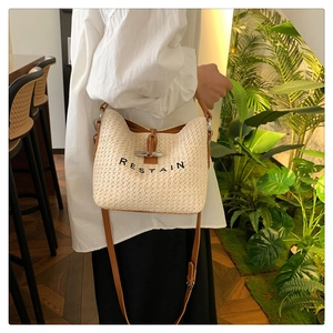 Détail du sac seau tissé avec bordure en cuir marron et broderie RESTAIN