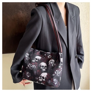 Dettaglio della stampa floreale con teschio su borsa in nylon e tracolla in pelle bordeaux
