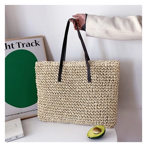 Chic beige woven straw tote bag with dark brown leather handles for spring fashion