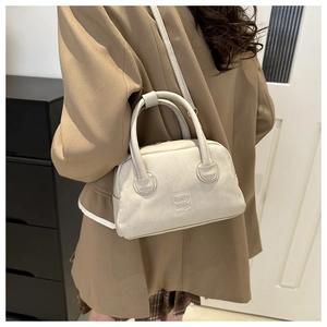 Detail view of the beige PU leather pillow bag with lady bags embossed logo and shoulder strap