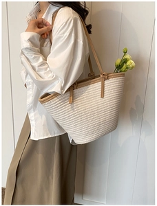 Détail du tissu tissé et de la bandoulière en cuir marron sur ce sac à bandoulière épuré