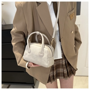 Detail of vintage beige PU leather Boston bag with lady bags embossed text and gold zippers