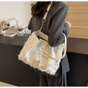 Detailansicht der weißen Fransen-Stofftasche mit eleganter Perlen-Zierkette