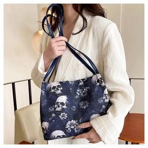 Dettaglio della borsa tote blu in tessuto Oxford con motivi a teschi e decori floreali