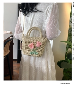 Detail of hand-woven straw bag featuring pink crochet tulip floral decorations