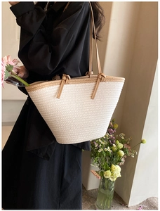 Détail du sac cabas blanc tressé avec fines bandoulières marron porté par un mannequin