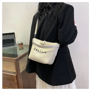Détail du sac bandoulière en paille tressée avec bordure en cuir et fermoir en argent