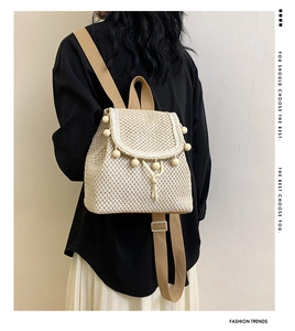 Close-up of beige woven backpack with wooden bead detail and adjustable canvas straps