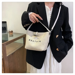 Détail du sac cabas tissé blanc cassé avec logo RESTAIN noir et bandoulière fine