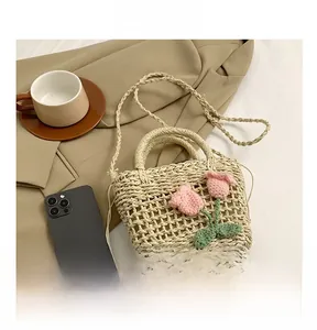 Detail of hand-woven straw handbag with pink crochet tulips and drawstring liner