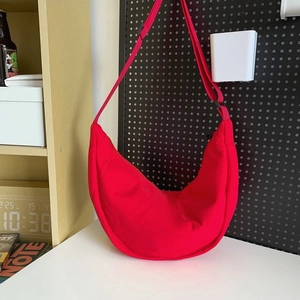 Vibrant red nylon crescent crossbody bag with adjustable wide shoulder strap for women