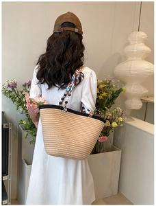 Détail du sac cabas tissé avec sangle florale colorée et perles en bois foncé