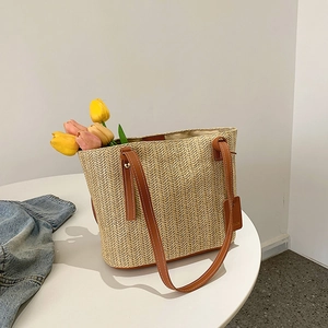 Fashionable straw tote bag with brown leather handles and herringbone weave texture