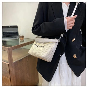 Vue détaillée d'un sac bandoulière blanc tissé avec broderie RESTAIN noire élégante