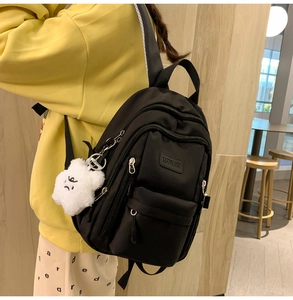Side view of black PU backpack with multi-layer zippers and cute white cloud charm detail
