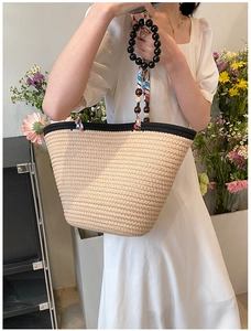 Détail du sac à bandoulière en paille tressée avec anse en foulard de soie et perles