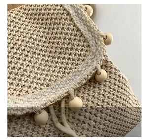 Close-up of woven straw texture and natural wooden beads decoration on a stylish handbag
