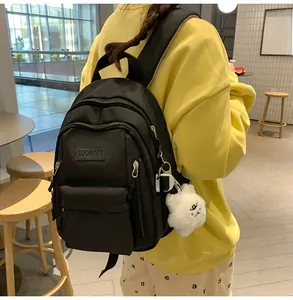 Close-up of black nylon fashion backpack with star pendant in a cafe setting