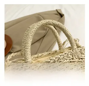 Detail of woven straw handbag handle with pink crochet tulip decor and drawstring closure