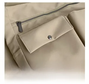 Dettaglio borsa Oxford kaki con cerniere in metallo e tasche con bottoni a pressione in metallo