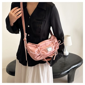 Détail du sac à bandoulière rose plissé en PU avec nœuds et accent en métal argenté