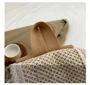 Close-up of the woven texture and reinforced canvas strap handle on a stylish tote bag