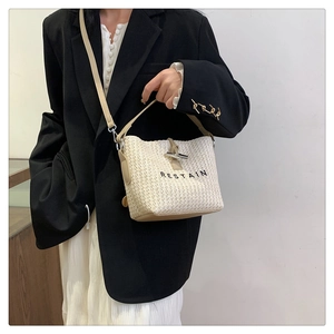 Détail d'un sac à main tissé avec garniture en cuir et boucle bambou argentée