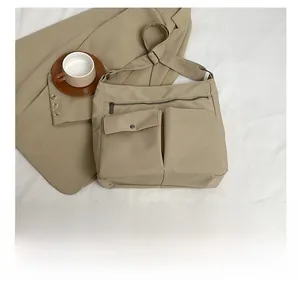 Dettaglio della borsa a tracolla in tessuto Oxford kaki con molteplici tasche a zip