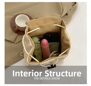 Detail view showing large interior capacity of beige straw backpack with various essentials