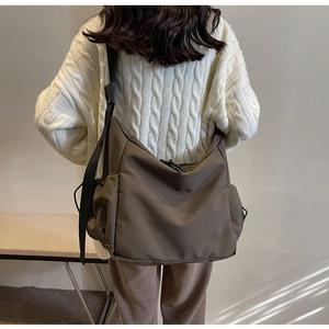 Rear view of a model wearing the large capacity khaki nylon crossbody bag in casual style