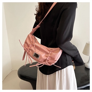 Détail du sac baguette en similicuir rose avec plis et nœud décoratif en soie