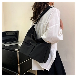 Vista laterale dettagliata della borsa a tracolla in nylon nero con tracolla regolabile