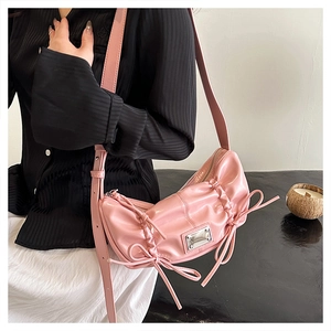 Détail du sac en similicuir rose froncé avec plaque argentée et nœud en ruban élégant
