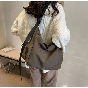 Macro detail of brown nylon tote bag with wide strap and large functional plastic buckle