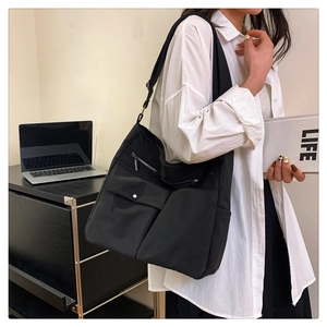 Dettaglio della borsa a tracolla nera in nylon con tasche multiple in scena di vita