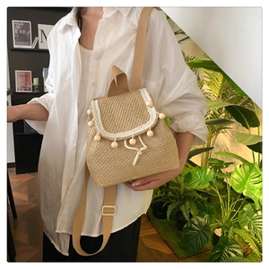 Detail of woven straw backpack with lace trim and wooden beads in a natural lifestyle setting