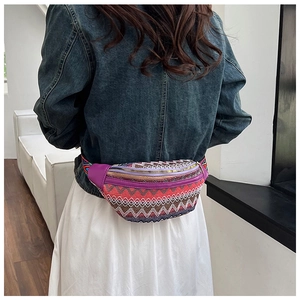 Macro detail of bohemian embroidered waist bag showing colorful geometric weaving patterns